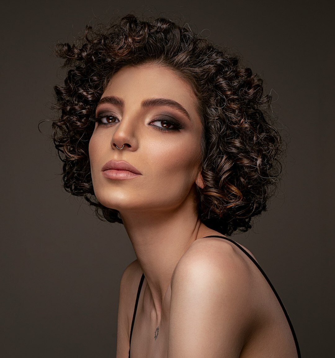 Studio portrait of a woman photographer with curly hair